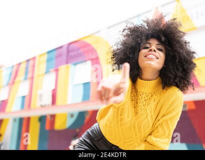 Femme souriante pointant à l'extérieur Banque D'Images