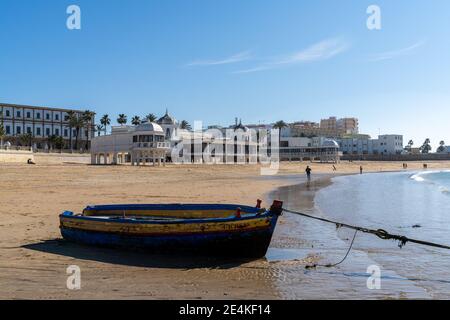 Cadix, Espagne - 16 janvier 2021 : vue sur la plage de la Caleta à Cadix avec des bateaux de pêche en bois bloqués à marée basse Banque D'Images