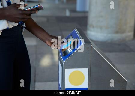 Femme d'affaires qui scanne les billets à la machine en étant debout dans le métro Banque D'Images