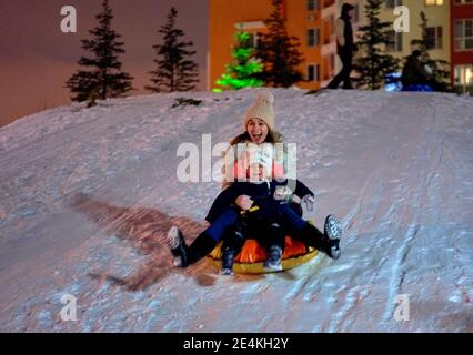 Maman fils monter sur une luge hiver gonflable tube. Plaisir d'hiver pour toute la famille Banque D'Images