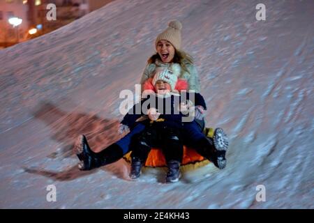 Maman fils monter sur une luge hiver gonflable tube. Plaisir d'hiver pour toute la famille Banque D'Images