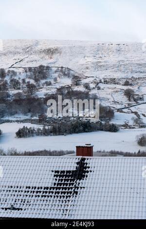 Couverture de neige blanc frais sur le toit de la maison et cheminée, fond ciel blanc, belle saison d'hiver au Royaume-Uni. Banque D'Images