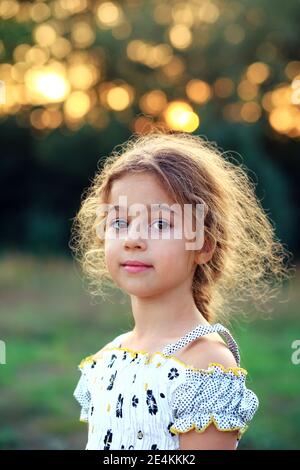 Portrait de la belle petite fille souriante du parc d'été. Enfant heureux regardant la caméra Banque D'Images