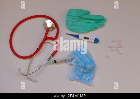 Matériel de concept médical: Stéthoscope et pilules de médecine, seringue, gant chirurgical, thermomètre numérique sur fond blanc. Vaccination contre le virus Corona. Banque D'Images