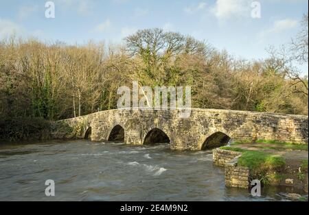 L'ancien pont plongeant au-dessus de la rivière Ogmore près de Merthyr Maw après une forte pluie. Les trous du pont devaient pousser les moutons dans la rivière. Banque D'Images