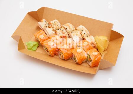 Service de livraison des rouleaux de nourriture japonaise dans une boîte en carton sur un arrière-plan blanc Banque D'Images