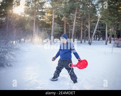 Garçon jouant avec la neige. Photo de haute qualité. Banque D'Images