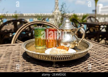 Pot et verres de thé à la menthe sur un plateau métallique dans un café à Tanger, au Maroc Banque D'Images