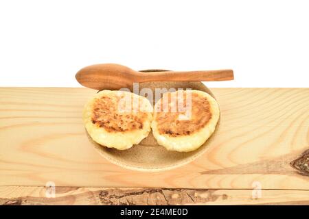 Deux plats frits savoureux bouche-bouche appétissant bouche-bouche crêpes saveurs, se trouvent sur une soucoupe légère en céramique avec une cuillère à café en bois. Banque D'Images