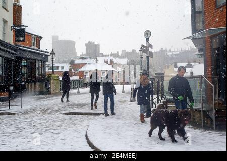 Eton, Windsor, Berkshire, Royaume-Uni. 24 janvier 2021. Les marcheurs arrivent à Eton en traversant le pont Windsor dans la neige. Ce matin, quelques heures de neige ont éclairci le verrouillage de Covid-19 alors que les gens se rendaient à Eton pour une promenade. Eton reste calme alors que le Collège Eton reste fermé pendant le confinement du coronavirus Covid-19. Crédit : Maureen McLean/Alay Live News Banque D'Images