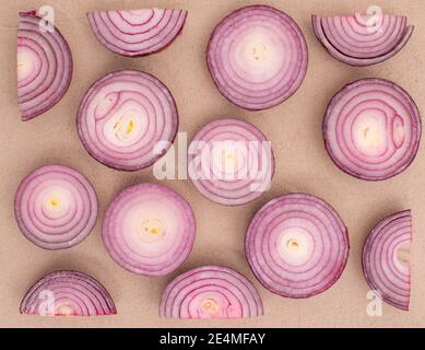 Motif oignon rouge sur fond de couleur sable, légumes à plat Banque D'Images