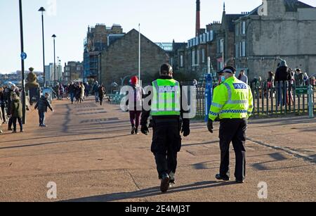 Portobello, Édimbourg, Écosse, Royaume-Uni. 24 janvier 2021. Soleil de l'après-midi et 1 degré centigrade au bord de la mer relativement occupé. Photo : deux policiers font un passage de routine le long de la promenade. Banque D'Images