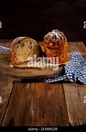 Kraffin gâteau de Pâques. Kraffins aux raisins secs, fruits confits et graines de pavot, arrosés de sucre en poudre. Gros plan de gâteau maison. Brut. Banque D'Images