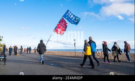 Worthing UK 24 janvier 2021 - UN homme avec une grande bannière remerciant le NHS pour leur travail pendant le coronavirus COVID-19 pandémie marche le long du front de mer de Worthing sur une belle journée ensoleillée : Credit Simon Dack / Alay Live News Banque D'Images