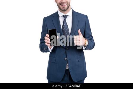 Un homme d'affaires heureux à moitié face Donnez les pouces à un modèle de téléphone portable approuvé isolé sur blanc, approbation. Banque D'Images