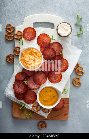 Croustilles de salami cuites au four avec sauces au fromage Banque D'Images