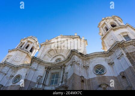 Une vue en angle bas de la cathédrale dans l'ancienne Centre-ville historique de Cadix sous un ciel bleu clair Banque D'Images