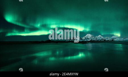 Aurores boréales / Aurora Borealis à Storsandnessanden, Lofoten, Norvège, la nuit en hiver, se reflète dans l'eau. Banque D'Images