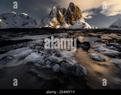 Pic emblématique épique de Hamnoy pendant un lever de soleil d'hiver, reflété dans les piscines glacées, Lofoten, Norvège Banque D'Images