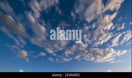 Nuages blancs moelleux en bleu ciel azur été coucher de soleil avec la lumière du soleil. Panorama d'arrière-plan Cloudscape. Soir crépuscule beau temps fond naturel. Banque D'Images