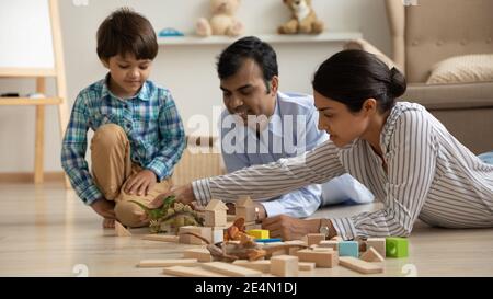 Les parents de race mixte soignants construisent le parc dino avec le fils d'avant-garde Banque D'Images