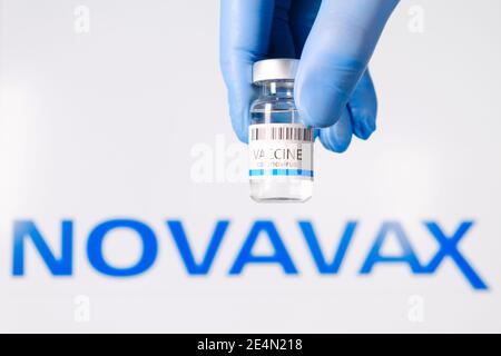 Vaccin Novavax dans la bouteille dans les médecins main dans les gants en caoutchouc sur le fond du logo, janvier 2021, San Francisco, Etats-Unis Banque D'Images