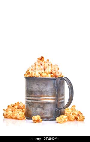 Délicieux pop-corn sucré au caramel dans une tasse rétro en métal ancien, isolée sur fond blanc Banque D'Images