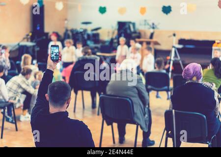 Parents à l'exécution d'enfants à la maternelle ou à l'école. Enfants sur scène. De nombreux parents regardent les enfants dans le hall pendant Banque D'Images