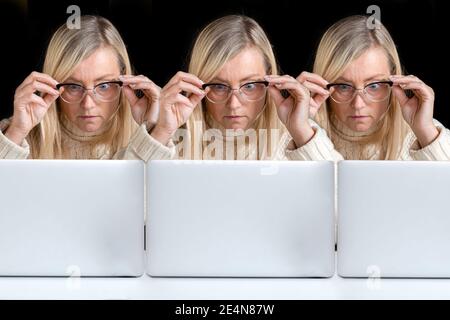 image clonée, trois femmes d'âge moyen émotionnelles identiques surpris regardant un écran d'ordinateur, un espace de copie, le concept de poster créatif Banque D'Images