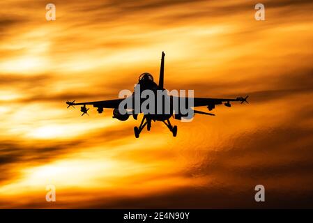 Un avion de chasse F-16 de l'armée de l'air belge est prêt à atterrir pendant un beau coucher de soleil. Banque D'Images