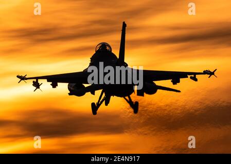 Un avion de chasse F-16 de l'armée de l'air belge est prêt à atterrir pendant un beau coucher de soleil. Banque D'Images