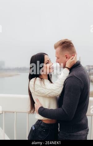 La jeune femme épouse doucement son homme sur le fond d'un paysage brumeux. Photo de haute qualité Banque D'Images