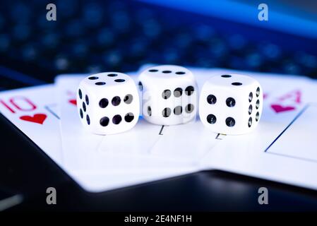 Plate-forme de jeu en ligne, casino et affaires de jeu. Cartes et dés sur le clavier de l'ordinateur portable, ton bleu. Banque D'Images