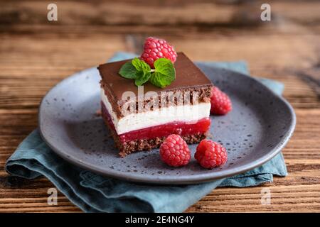 Dessert sucré, délicieux cheesecake au chocolat et à la framboise, recouvert de glaçage au chocolat Banque D'Images