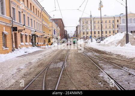 Helsinki. Finlande. 19 janvier 2021 hiver, Snowy Helsinki. Transport moderne dans une rue enneigée. Vieilles façades colorées de bâtiments sur la rue couverte de neige en hiver dans la ville. Transposor. Photo de haute qualité Banque D'Images