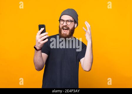 Photo d'un boxeur à barbe qui se met en colère contre un smartphone. Banque D'Images