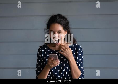 Surprise jeune femme choquée par la bonne affaire de vente sur téléphone portable Banque D'Images