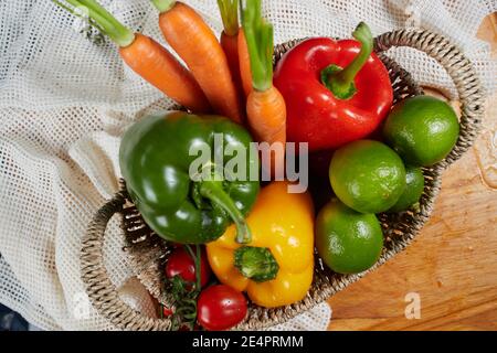 Paniers pleins de légumes. Carottes, poivrons, concombres, limes, tomates en paniers en osier. Gros plan. Banque D'Images