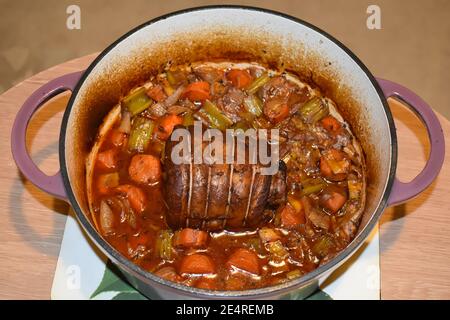 Poitrine de bœuf cuite lentement dans une casserole en fonte avec carottes, oignons céleri, thym et Laurier. Les Briskets sont bon marché de coupe de boeuf idéal pour la longue cuisson Banque D'Images