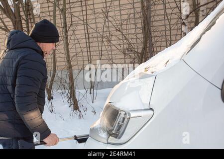 L'homme nettoie la neige de sa voiture. Photo de haute qualité Banque D'Images
