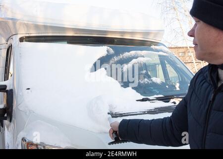L'homme nettoie la neige de sa voiture. Photo de haute qualité Banque D'Images