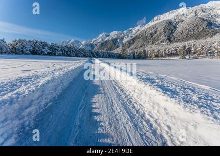 Sentier de randonnée couvert de neige profonde à travers le paysage alpin ensoleillé d'hiver à Wildermieming, Tirol, Autriche Banque D'Images
