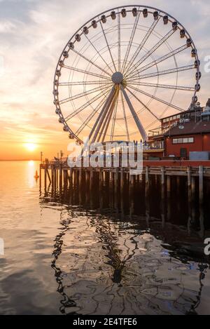 La grande roue de Seattle s'élève à 175 mètres au-dessus de l'embarcadère 57, surplombant les gratte-ciel de Seattle et Elliott Bay tandis que le soleil se couche à l'ouest Banque D'Images