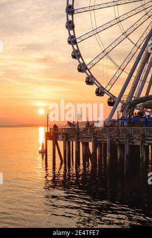 La grande roue de Seattle s'élève à 175 mètres au-dessus de l'embarcadère 57, surplombant les gratte-ciel de Seattle et Elliott Bay tandis que le soleil se couche à l'ouest Banque D'Images