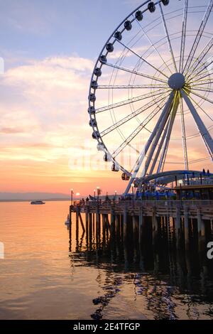 La grande roue de Seattle s'élève à 175 mètres au-dessus de l'embarcadère 57, surplombant les gratte-ciel de Seattle et Elliott Bay tandis que le soleil se couche à l'ouest Banque D'Images