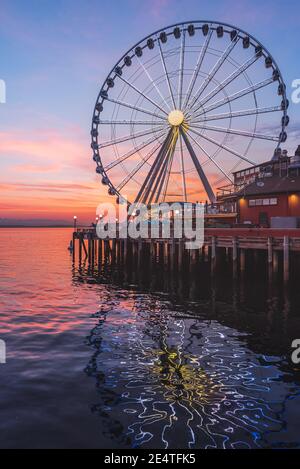 La grande roue de Seattle s'élève à 175 mètres au-dessus de l'embarcadère 57, surplombant les gratte-ciel de Seattle et Elliott Bay tandis que le soleil se couche à l'ouest Banque D'Images