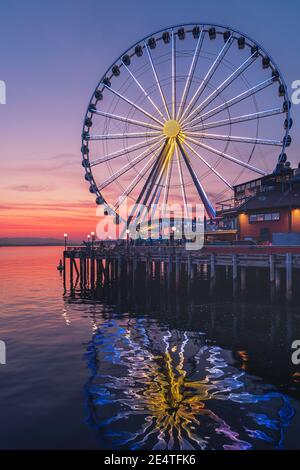 La grande roue de Seattle s'élève à 175 mètres au-dessus de l'embarcadère 57, surplombant les gratte-ciel de Seattle et Elliott Bay tandis que le soleil se couche à l'ouest Banque D'Images