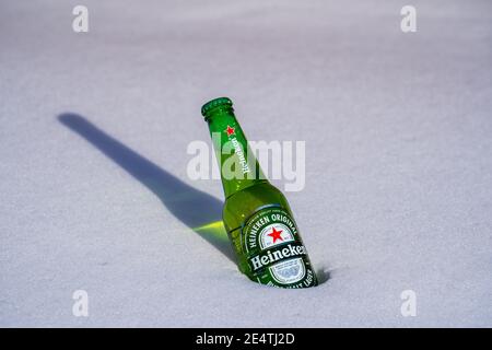 Kiev, Ukraine - 21 janvier 2021 : bouteille de bière Heineken Lager sur un lit de neige et de fond blanc Banque D'Images