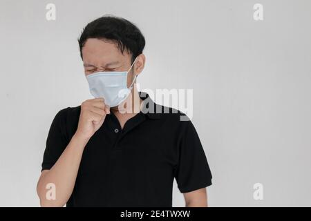 La grippe et la toux de l'homme asiatique malade est assis avec le masque. Concept de maladie, de grippe, de douleur. Healthcare et Corona concepts. Banque D'Images