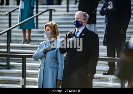 L'ancien président George W. Bush et l'ancienne première dame Laura Bush, se tiennent pour l'hymne national lors d'une cérémonie de la couronne au cimetière national d'Arlington, dans le cadre des 59e inauguration présidentielle le 20 janvier 2021 à Arlington, en Virginie. Banque D'Images